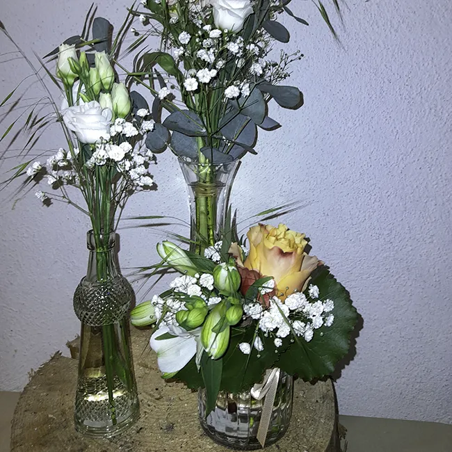 drei kleine Blumensträuße in Vasen