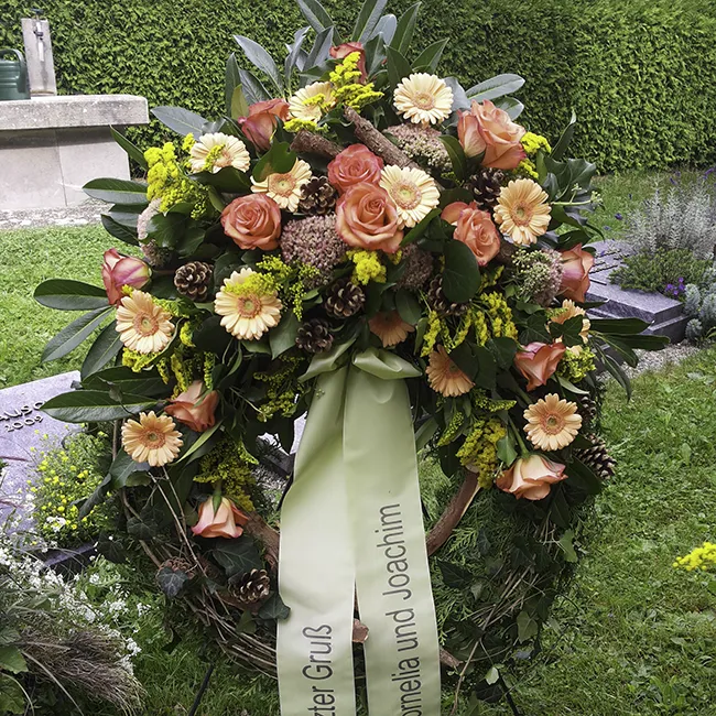 Blumenkranz für Beerdigung mit hellorangenen und rosafarbenen Blumen